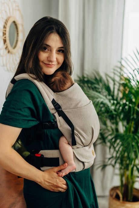 Mom comfortably carrying a baby in a LennyLight carrier, showcasing its lightweight design and stylish look.