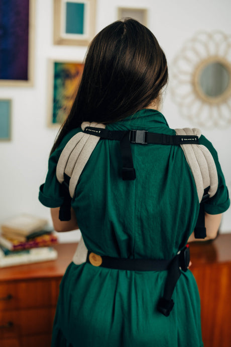 Woman wearing the LennyLight baby carrier in Peanut Butter color, showcasing adjustable straps and ergonomic design.