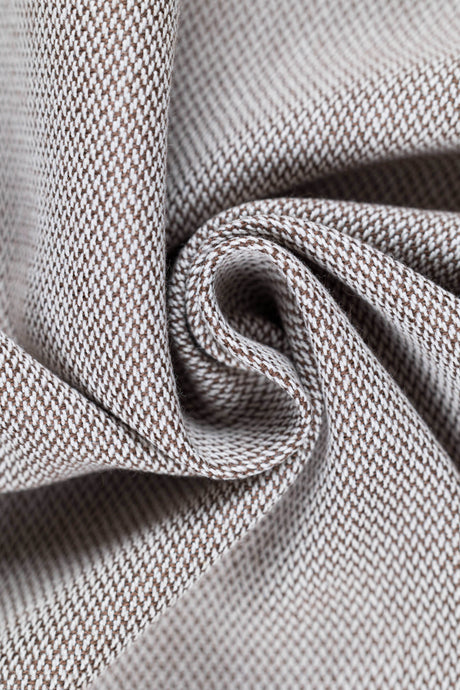 Close-up of soft, textured fabric in a brown and beige pattern, highlighting its intricate weave.