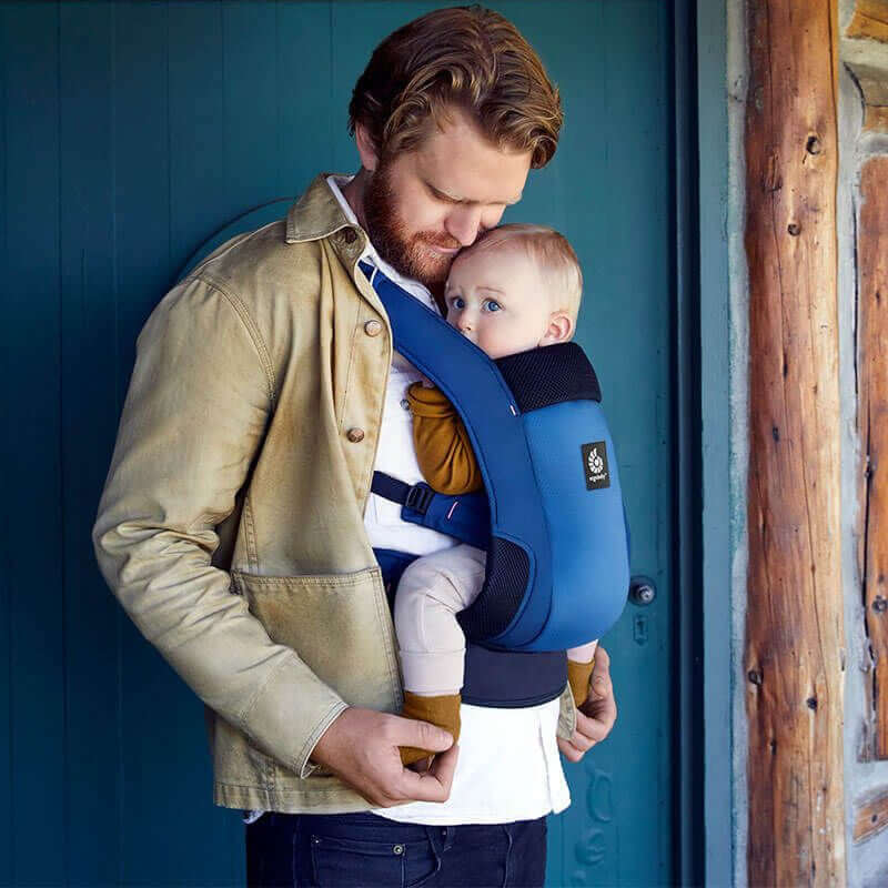 Father using Ergobaby Away, Compact & Foldable - Midnight Blue carrier with baby in front, promoting comfort and convenience | Babymaxi