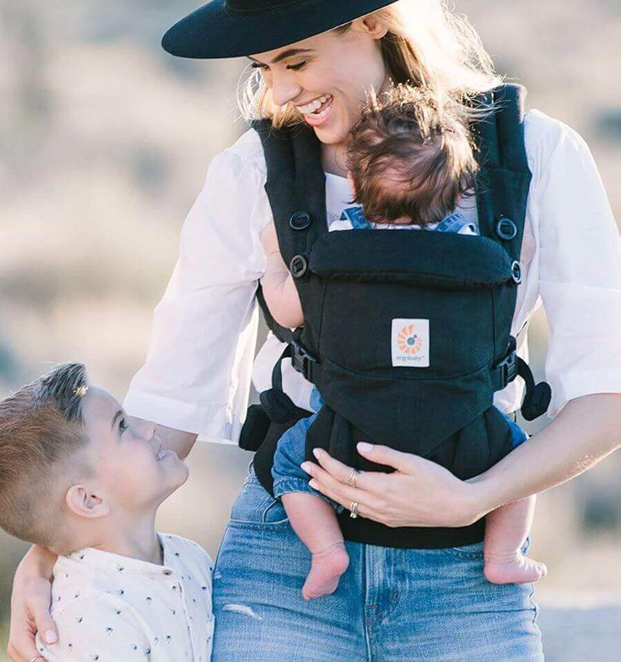 Mother wearing Ergobaby Omni Classic Cotton Carrier - Pure Black with baby while interacting with toddler | Babymaxi