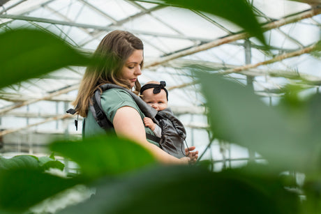 Woman holding a baby in a Neko carrier