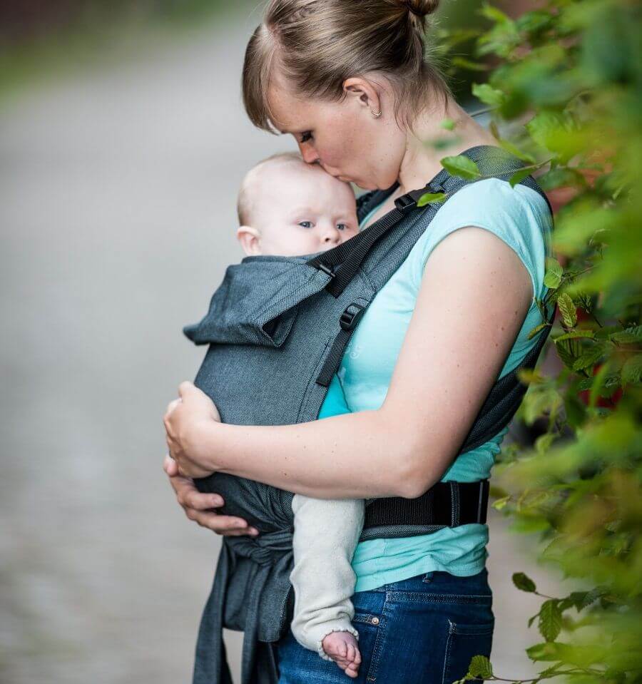 Woman holding baby in Storchenwiege Talemo Half-Buckle Baby Carrier - Graphite outdoors | Babymaxi