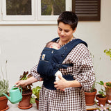Ergobaby Adapt - SoftFlex Mesh: Midnight Blue baby carrier with a mother holding a baby and watering can | Babymaxi