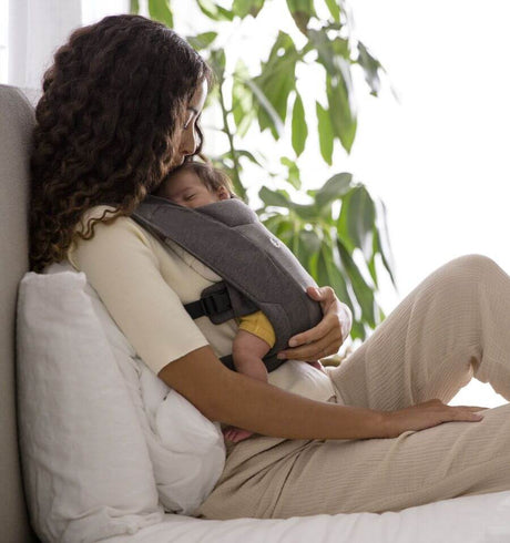 Ergobaby Embrace - Heather Grey baby carrier in use with mother holding newborn comfortably | Babymaxi