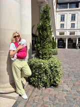 Woman wearing Nomad Air Roar baby carrier with infant smiling in Covent Garden outdoor setting