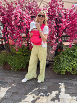 Mother smiling with baby in Nomad Air Roar carrier surrounded by pink cherry blossoms