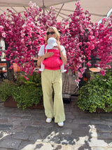 Infant wearing sun hat in Nomad Air Roar baby carrier viewed from behind with cherry blossoms