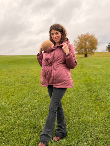 Mamalila Boston Babywearing Jacket Dark Rose, mom with baby in front carry standing in a green field