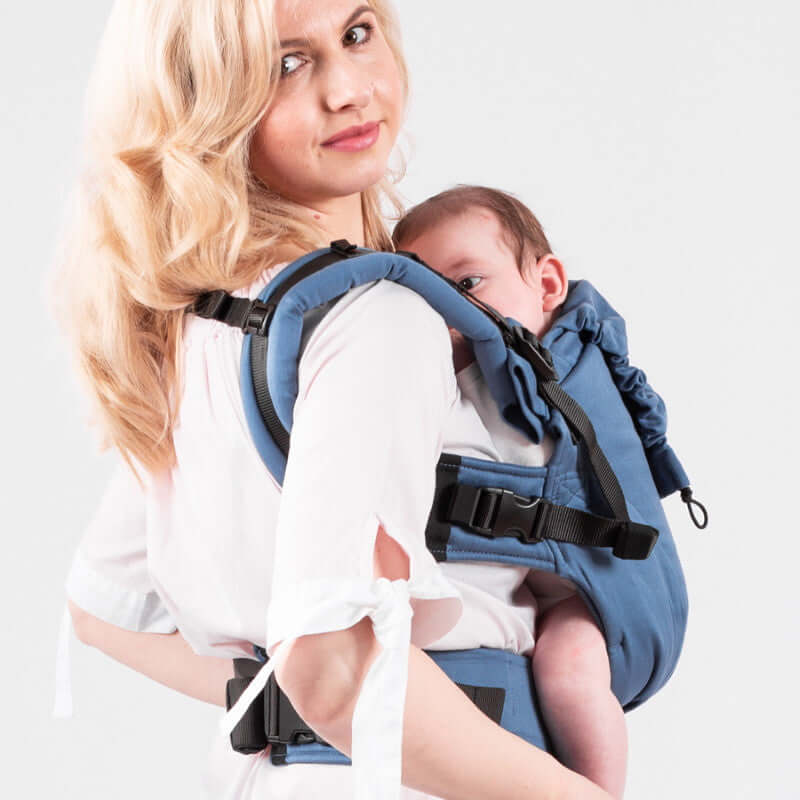 Woman using Isara The One - Bluestone ergonomic baby carrier with infant, showcasing comfort and style | Babymaxi