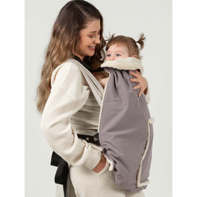 Isara Winter Baby Carrier Cover - Frosted Almond Taupe used by a smiling mom with her baby for cozy winter outings | Babymaxi