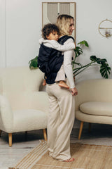 LennyLamb LennyPreschool (up to 30kg) - Little Herringbone Ebony Black toddler carrier with child, stylish indoor setting | Babymaxi