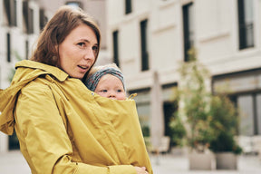 Mamalila Dublin Babywearing Coat – Mustard in use, showing stylish babywearing and comfort for mothers | Babymaxi
