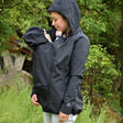 Mamalila Softshell Babywearing Jacket Allrounder - Black worn by a woman carrying a baby, showcasing its style and versatility | Babymaxi