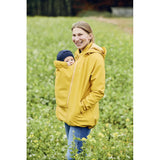 Mamalila Softshell Babywearing Jacket Allrounder - Mustard worn by a mother in a field with her baby | Babymaxi