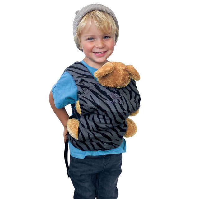 Happy child wearing Manduca Doll Carrier - Zebra with teddy bear, showcasing organic cotton design | Babymaxi