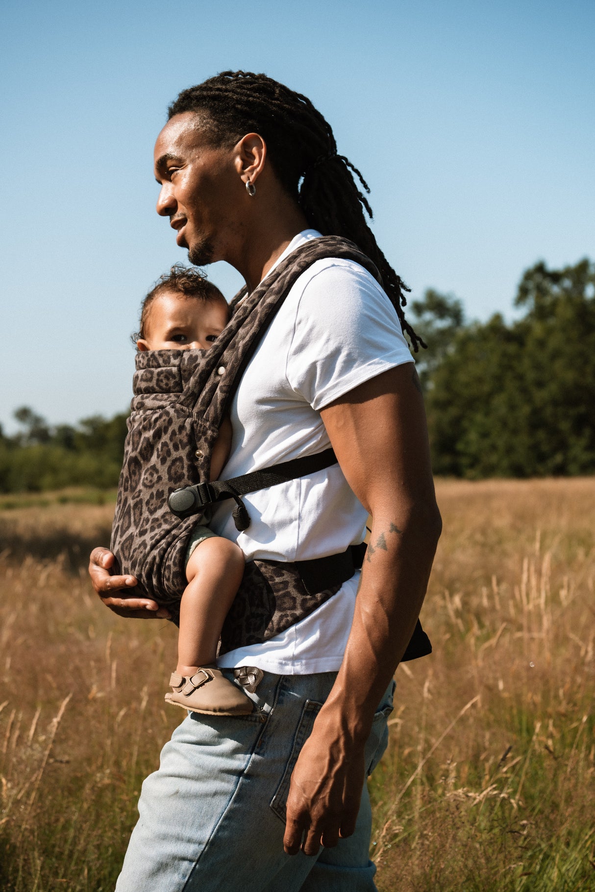Woman wearing Nomad Air jaguar baby carrier with toddler in outdoor setting