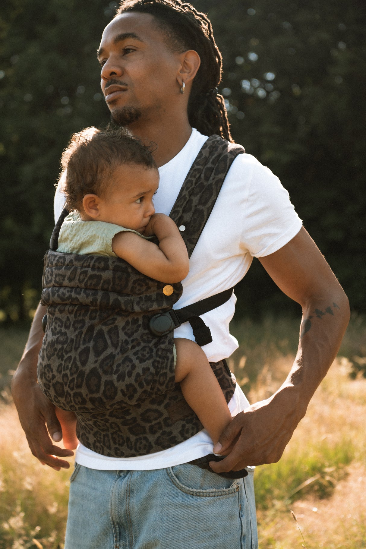 Woman in outdoor setting wearing Nomad Air baby carrier for hands-free parenting flexibility