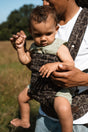 Nomad Air baby carrier in jaguar print worn by parent with happy toddler outdoors