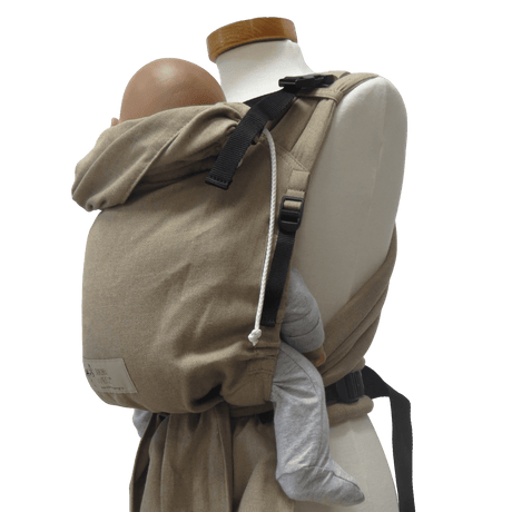 Close-up of Storchenwiege Talemo Half-Buckle Baby Carrier - Sand securely holding a baby, showcasing its adjustable buckles and wrap straps. | Babymaxi