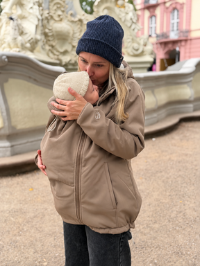 Mamalila Allrounder Winter softshell babywearing jacket in chestnut brown, mum carrying her baby on the front under the jacket